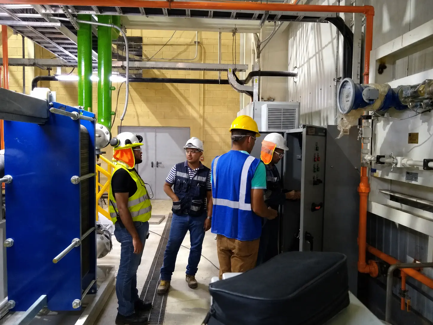 four workers working on electrical equipment